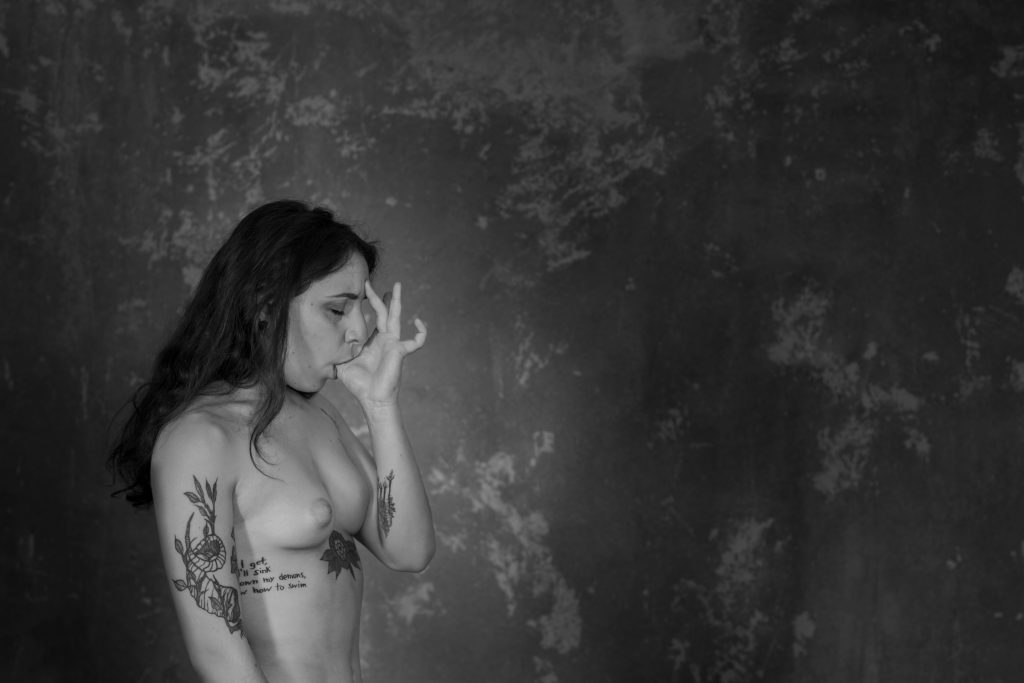 Abyssus abyssum invocat (Nueva galería en "Comunicación"). Fotografía en blanco y negro. Modelo tatuada desnuda. De perfil a la cámara, con el pulgar en la boca. Como metáfora de sexo oral. 